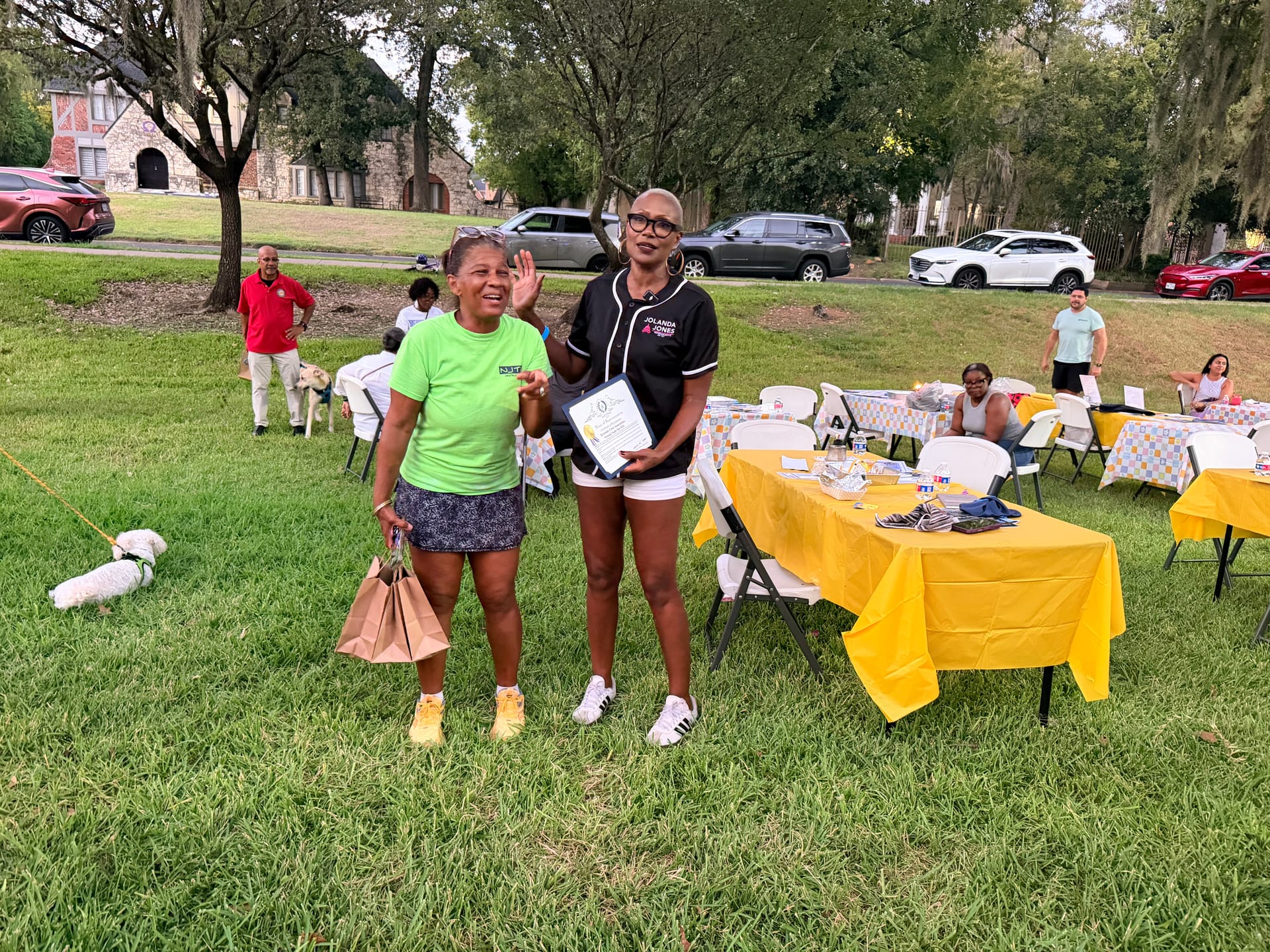 State Representative Jolanda Jones holds a framed certificate beside RCA Vice President Sharon Evans-Brooks, in a neon green shirt, on the lawn at Riverside Park.